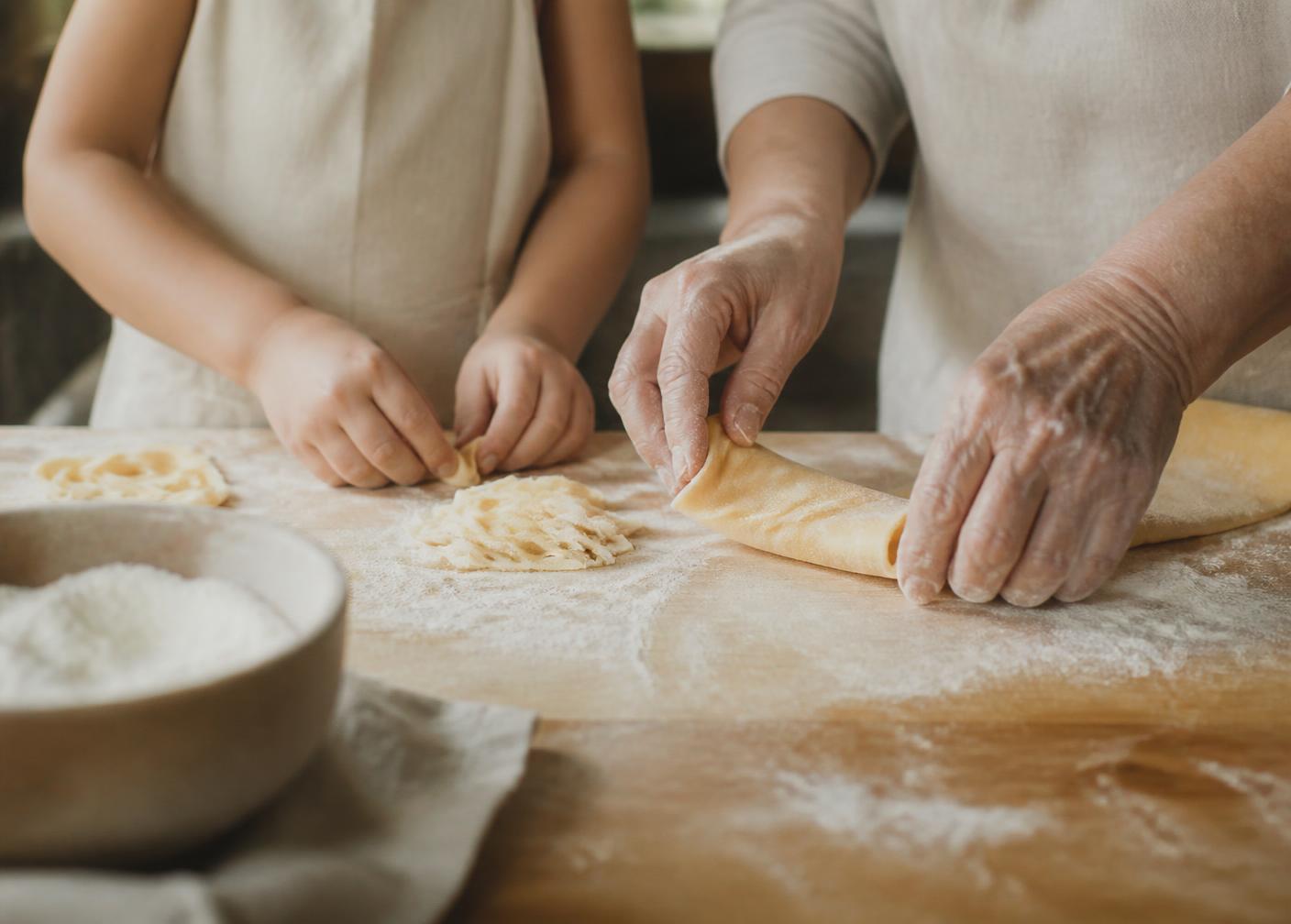 Großmutter und Enkelkind machen gemeinsam frische Pasta